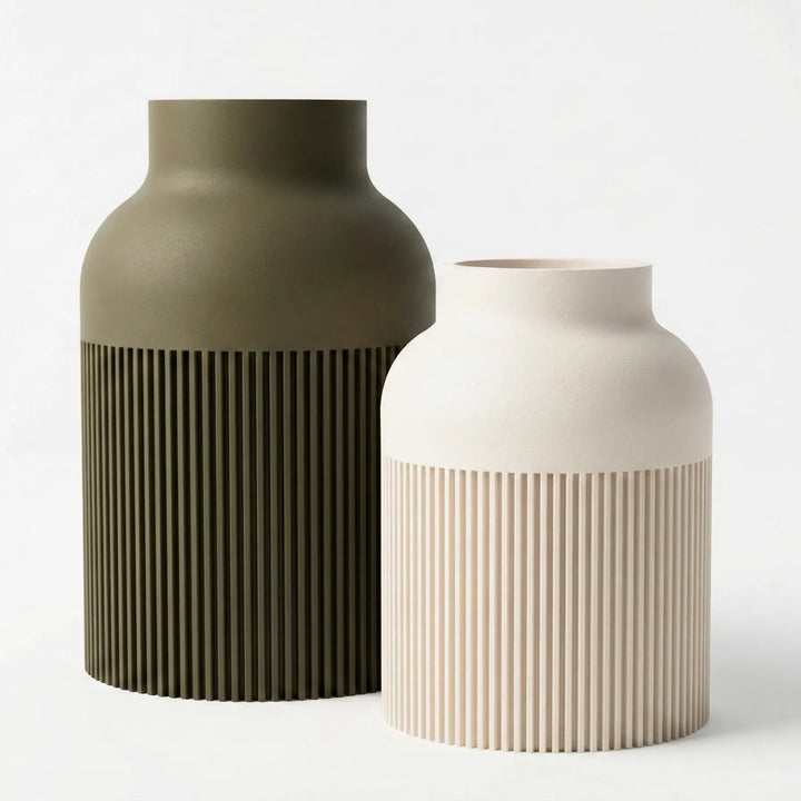 Jarrón decorativo de color gris carbón con diseño de lamas verticales onduladas y acabado mate sobre fondo blanco.