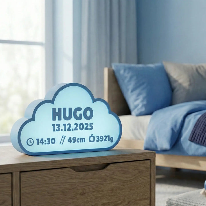 Lámpara infantil con forma de nube color naranja, personalizada con el nombre Hugo y sus datos de nacimiento, iluminada sobre una mesita de madera.
