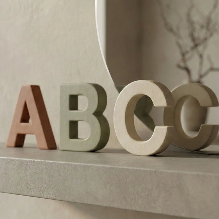 Lettres de jouets dispersées sur une table en bois clair, montrant la profondeur et une variété de couleurs.