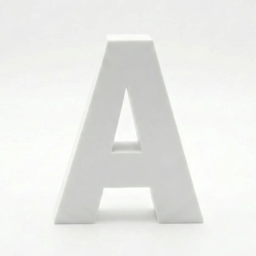 Composition de lettres décoratives (A, B, C, R, M) sur une étagère en pierre. Palette de couleurs terre cuite, vert sauge, crème et bleu grisâtre avec une finition mate.