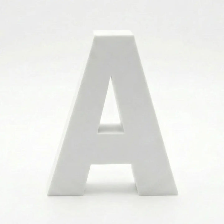 Composition de lettres décoratives (A, B, C, R, M) sur une étagère en pierre. Palette de couleurs terre cuite, vert sauge, crème et bleu grisâtre avec une finition mate.