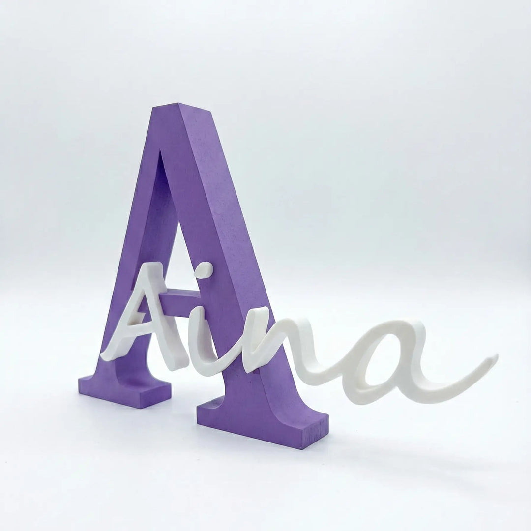 Letra personalizada con el nombre Aina en blanco y la A mayúscula en violeta