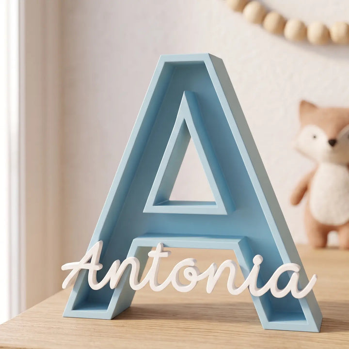 Letra A hueca personalizada en azul cielo con el nombre Antonia en blanco sobre una cómoda de habitación infantil
