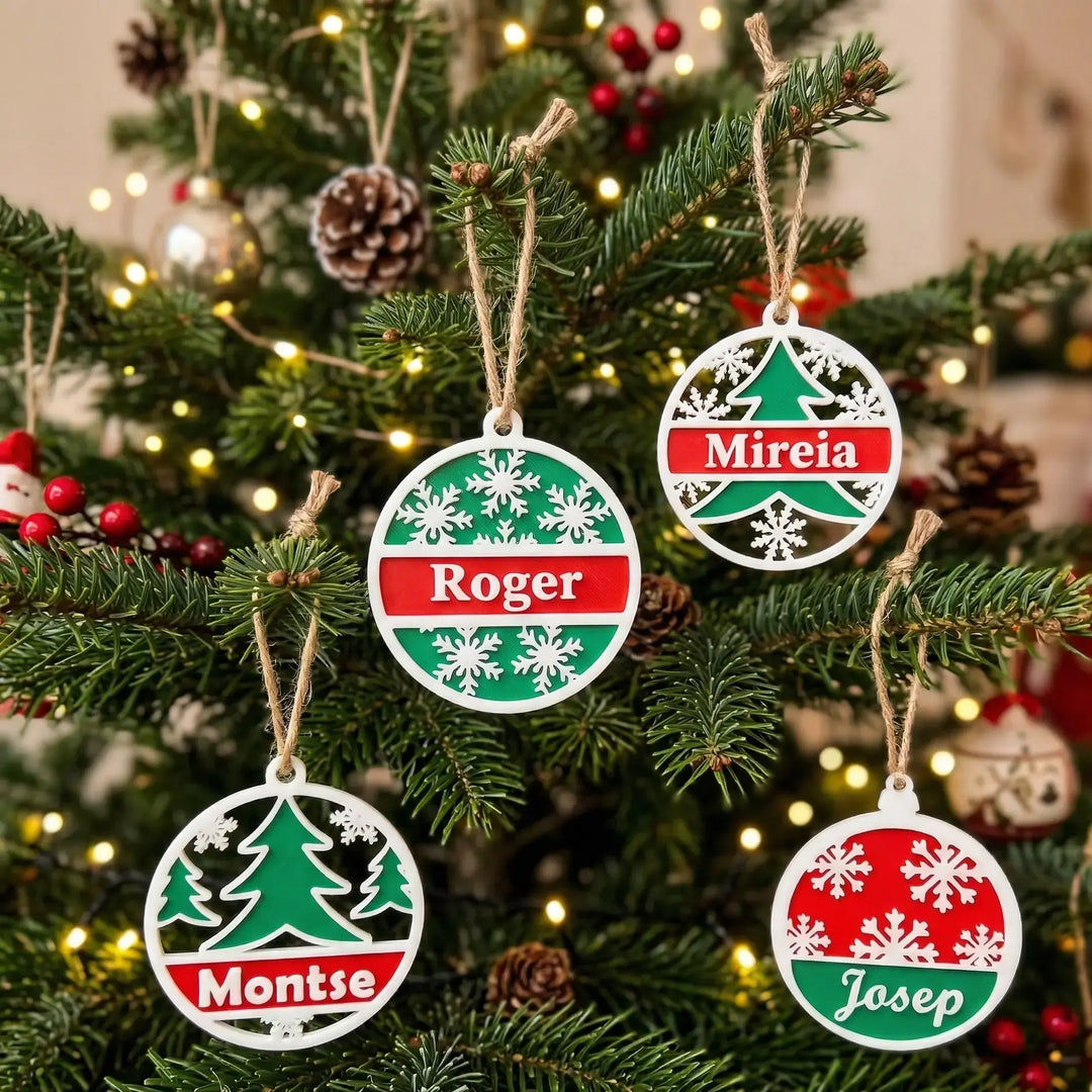 Conjunto de bolas navideñas tricolores personalizadas con nombres en rojo, verde y blanco sobre abeto iluminado.