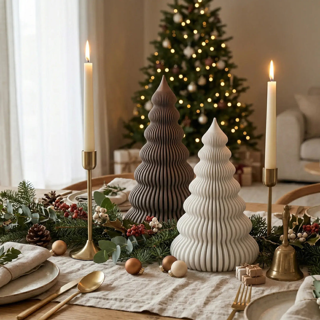 Pareja de árboles navideños acanalados en colores blanco y chocolate oscuro sobre mesa decorada de estilo nórdico.