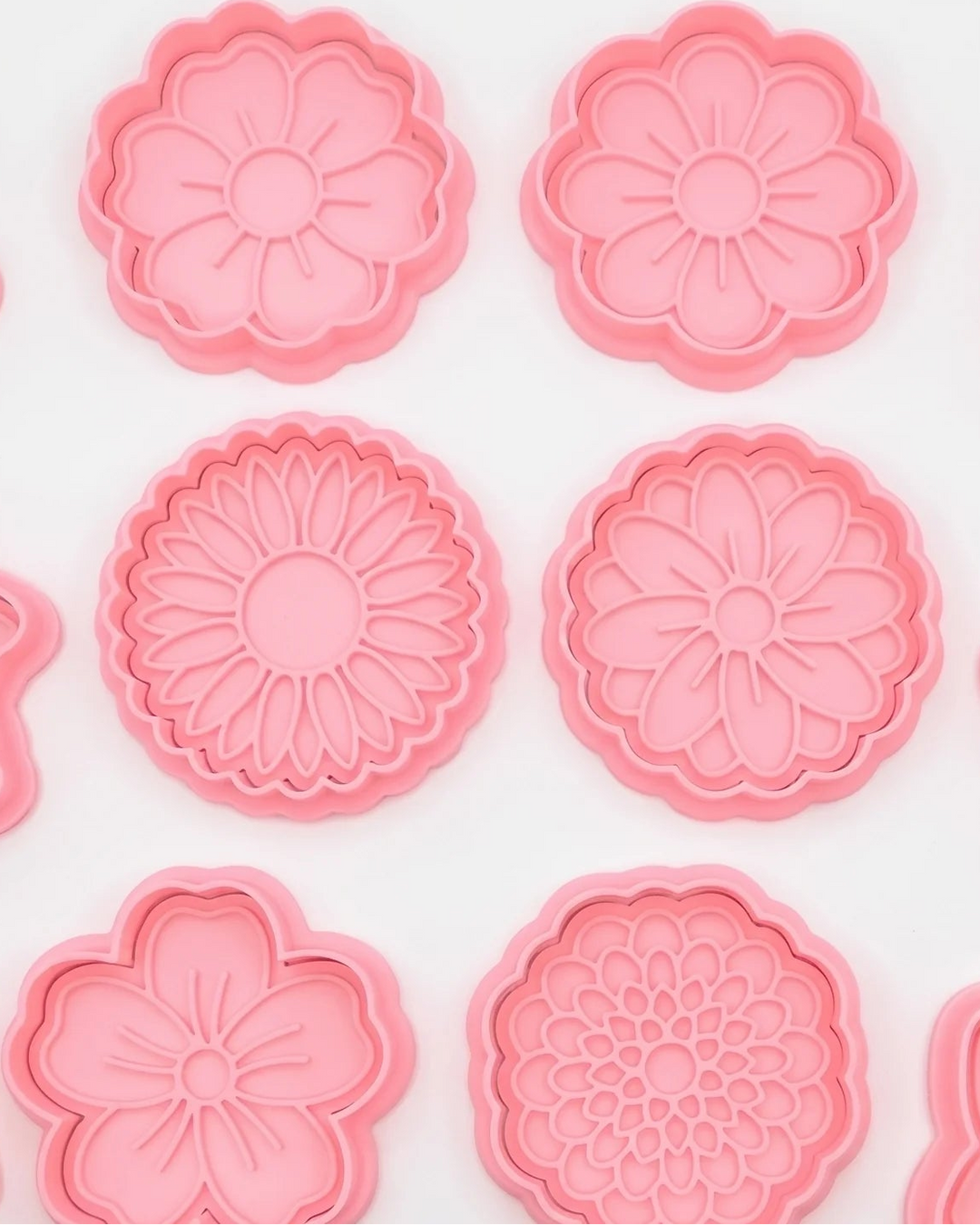 Blumen-Keksausstecher in Rosa mit Prägestempel für Blütenblätter.