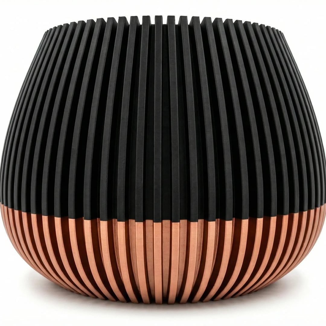 Primer plano de macetero con textura de líneas verticales, mitad superior negra y base color cobre satinado.