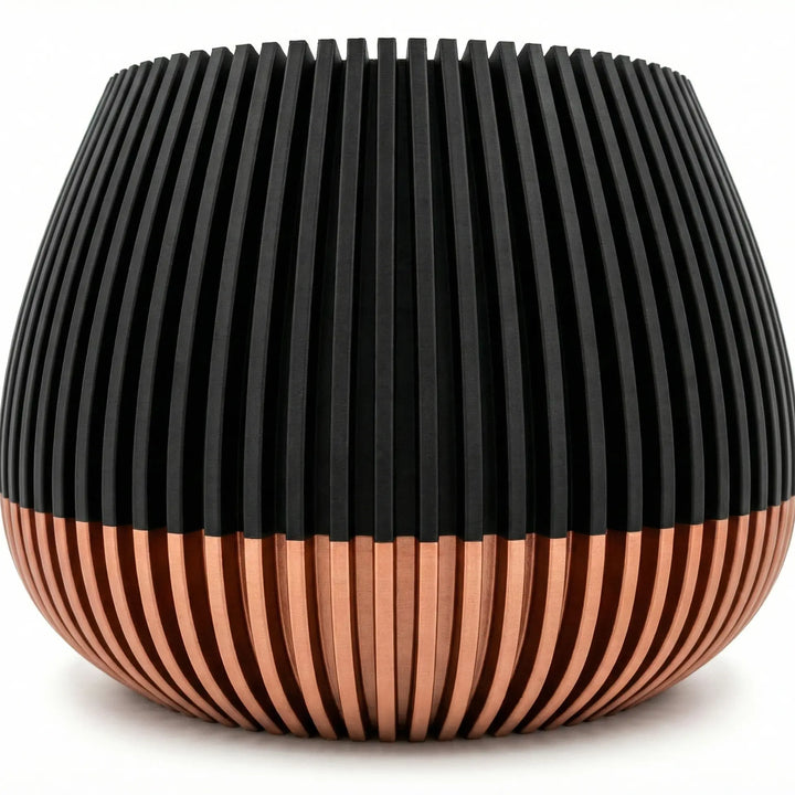 Primer plano de macetero con textura de líneas verticales, mitad superior negra y base color cobre satinado.