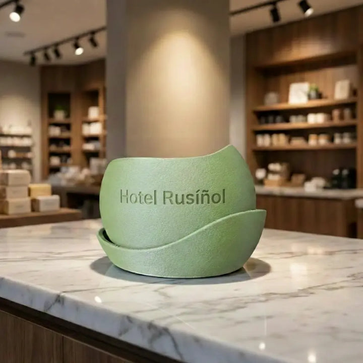 Olivgrüner kugelförmiger Blumentopf mit gewelltem Sockel, personalisierbar mit Ihrem Wunschtext als Reliefprägung auf einer Marmorleiste.