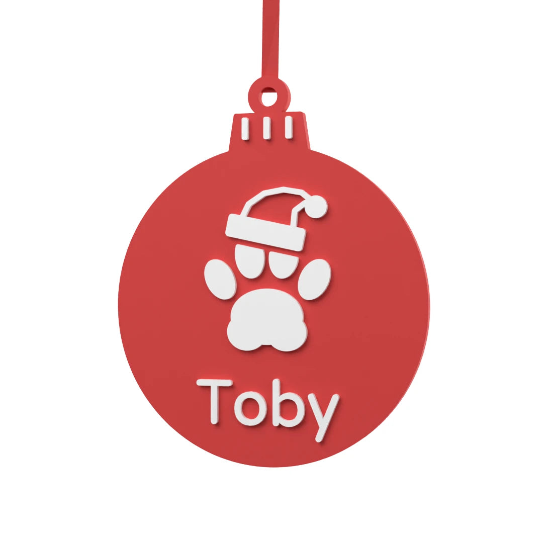 Bola de Navidad Mascota personalizada con huella de perro, gorro navideño y nombre en blanco sobre rojo escarlata