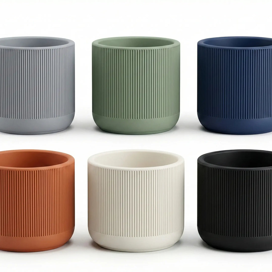 Set de 6 macetas texturizadas en colores gris, verde, azul, terracota, crema y negro, mostrando acabado mate y diseño estriado.