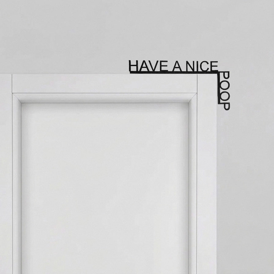 Corner Decorativo Puerta con mensaje Have a Nice Poop instalado en la esquina superior de un marco blanco.