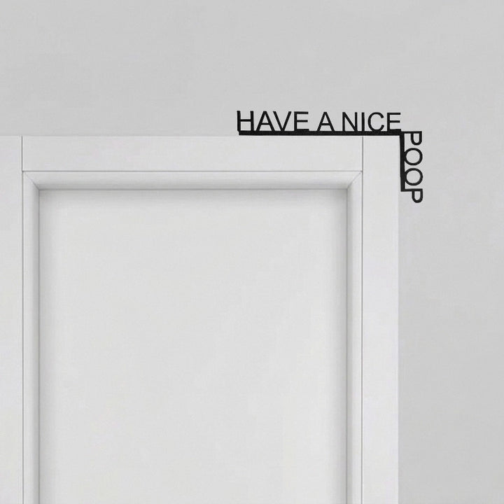 Tür-Eckendekoration mit „Have a Nice Poop“-Schriftzug, installiert an der oberen Ecke eines weißen Türrahmens.