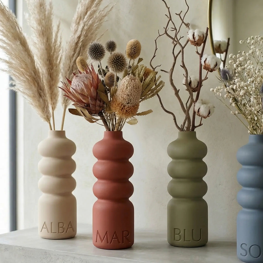 Beige golvende designvaas met naam ALBA in reliëf op de basis, organisch minimalistische stijl.