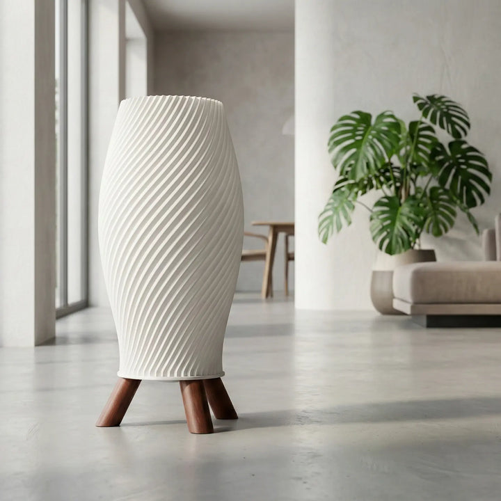 Cremefarbene Designer-Tischlampe im Helix-Design mit dunklem Dreibein-Stativ in Holzoptik auf weißem Untergrund.