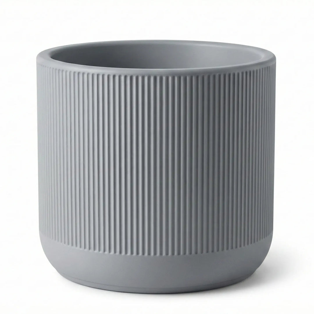 Primer plano de maceta cilíndrica gris con textura acanalada vertical y borde superior liso fabricada en PLA.