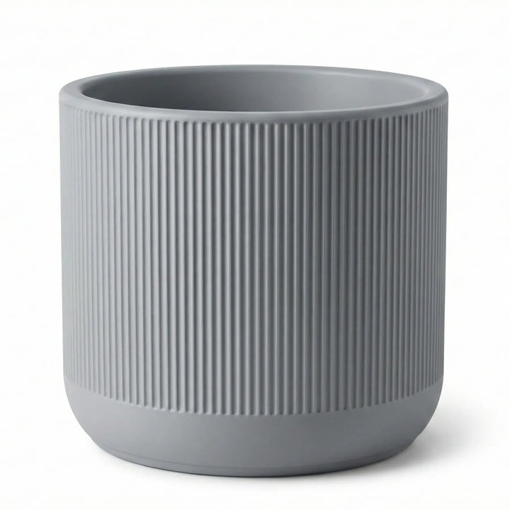 Primer plano de maceta cilíndrica gris con textura acanalada vertical y borde superior liso fabricada en PLA.