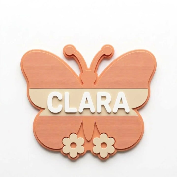 Placa de puerta infantil Mariposa con el nombre Clara, fijada con adhesivo por detrás