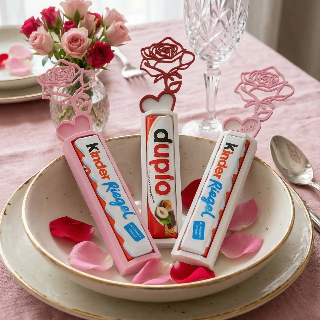 Soportes de dulces con forma de rosa en colores rosa y blanco decorando una mesa de boda con pétalos.